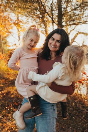 Playful outdoor photography session showing loving interactions against a backdrop of autumn trees.