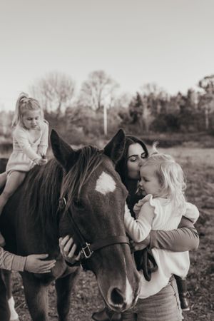 A series of black and white photos showing tender moments with a horse in a field at sunset.