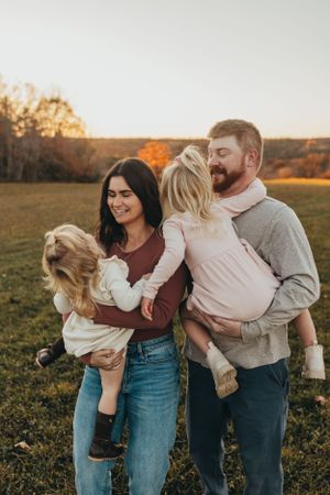 Family portrait series in casual attire during golden hour in an autumn field.