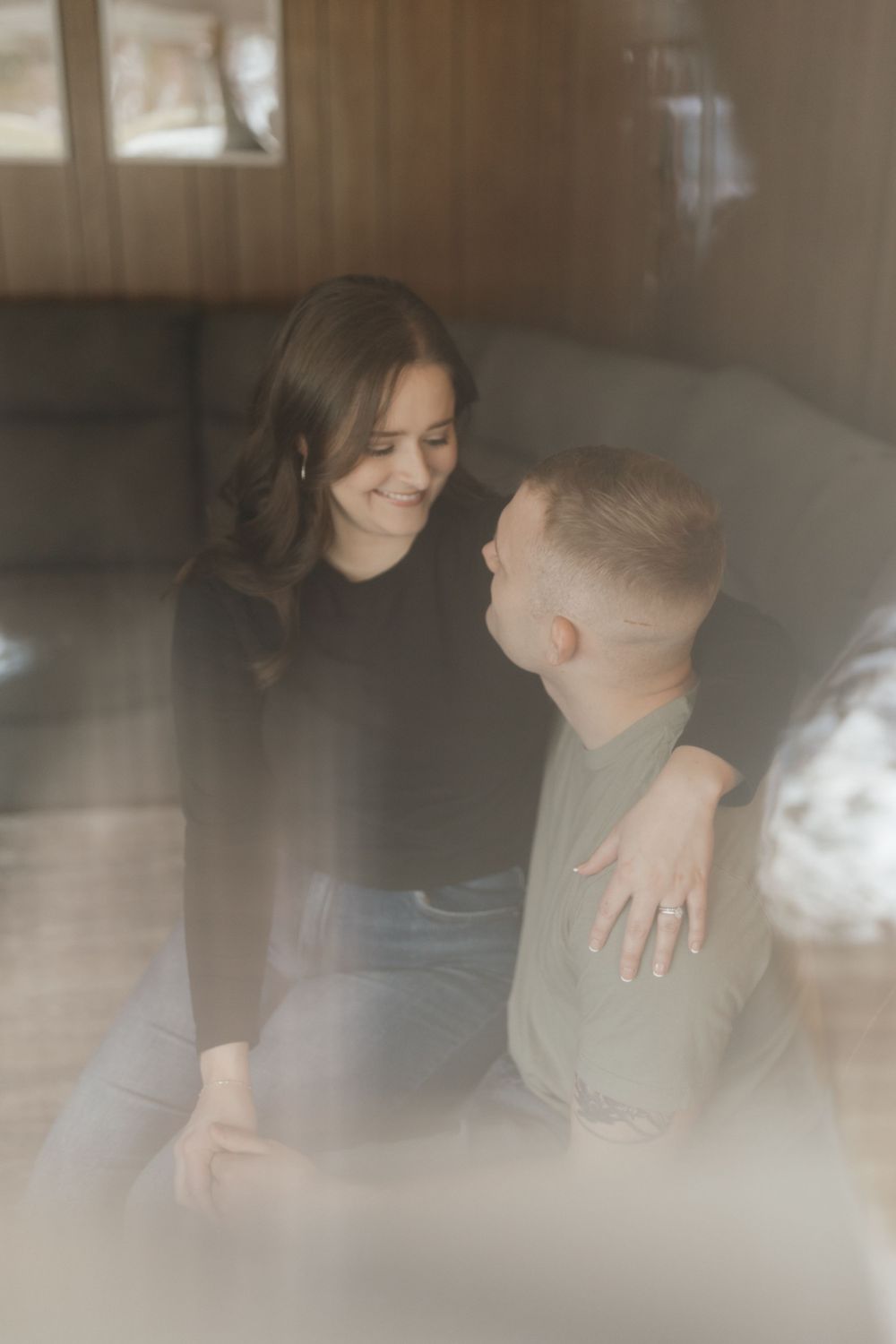 Dreamy portrait of couple sharing tender moment on couch with soft natural lighting.