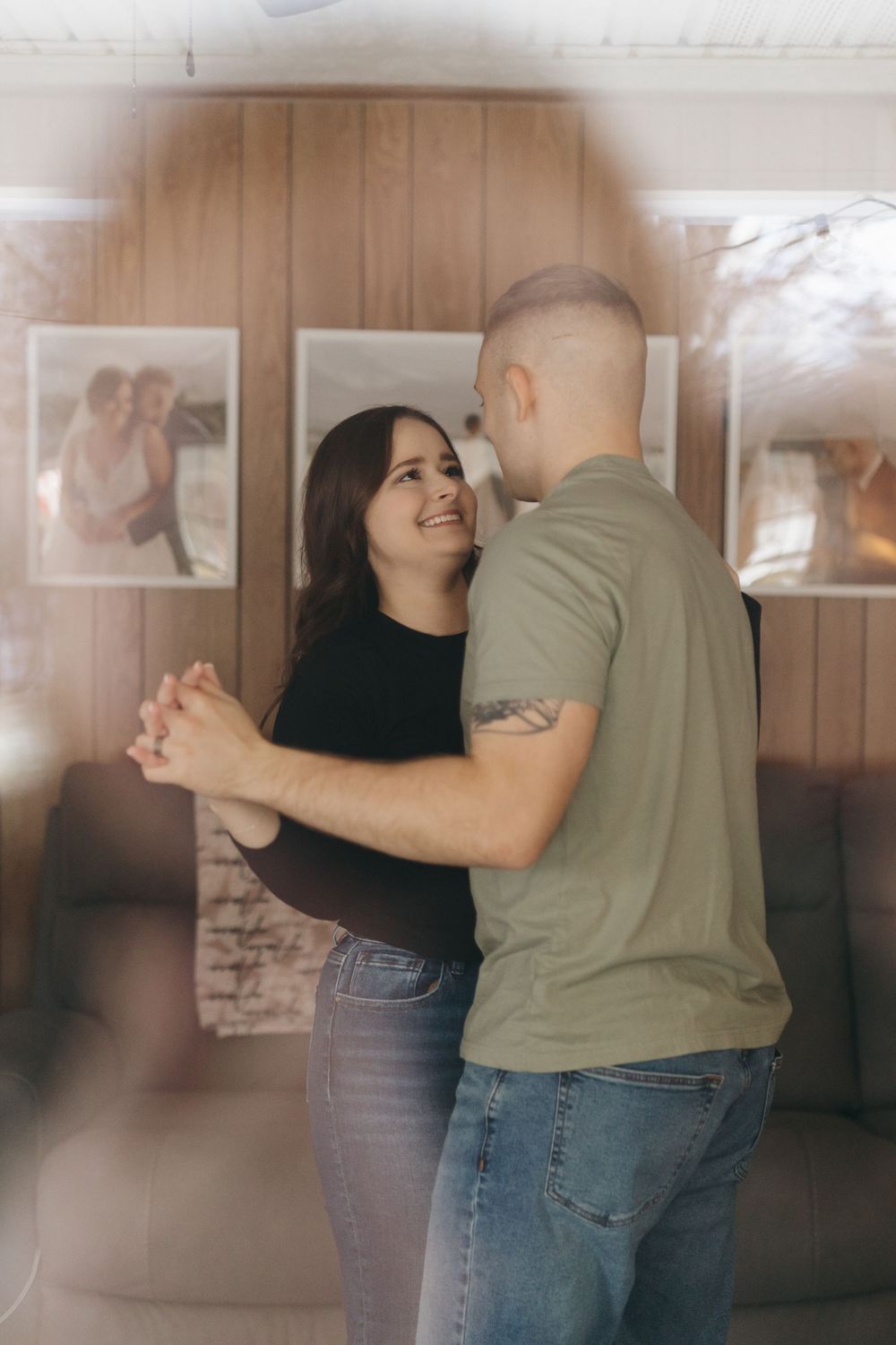 Joyful couple dancing and laughing together in cozy living room setting.