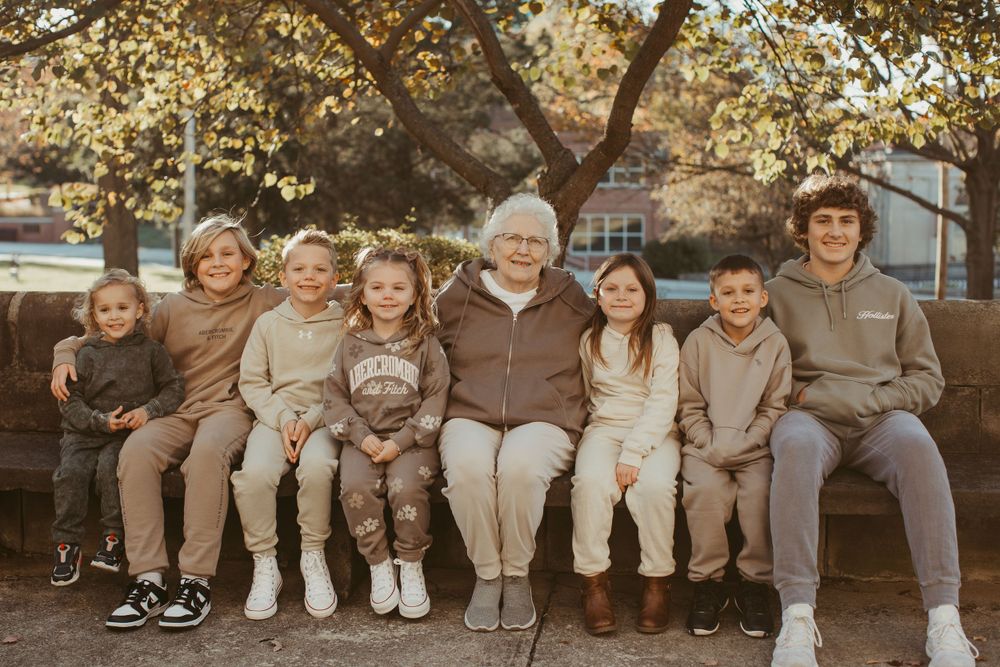 Group sitting together on outdoor steps during autumn season.