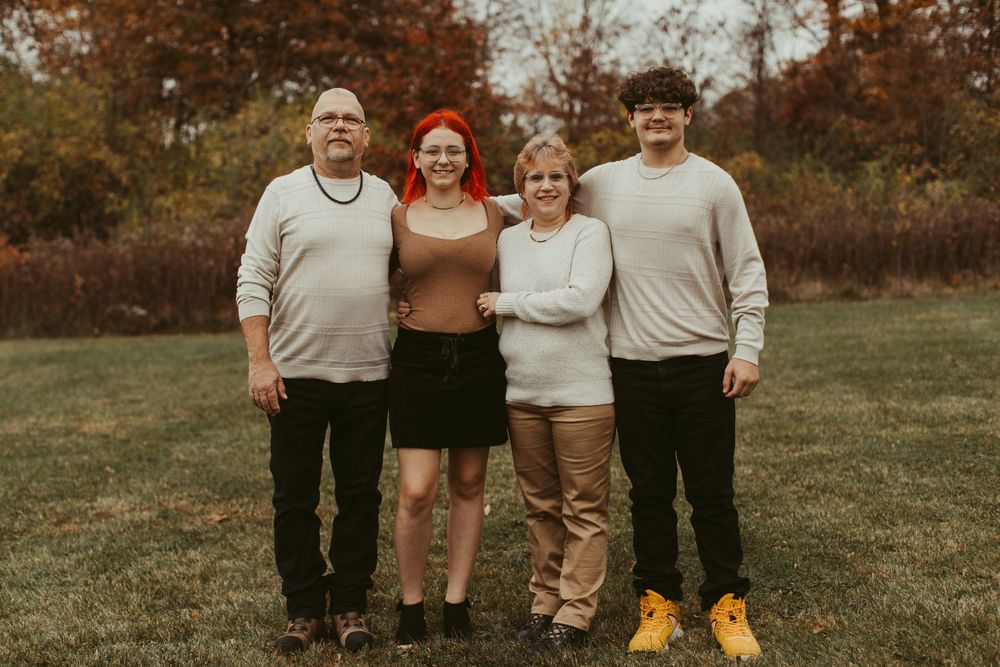 Group portrait of family members arranged in casual poses outdoors.