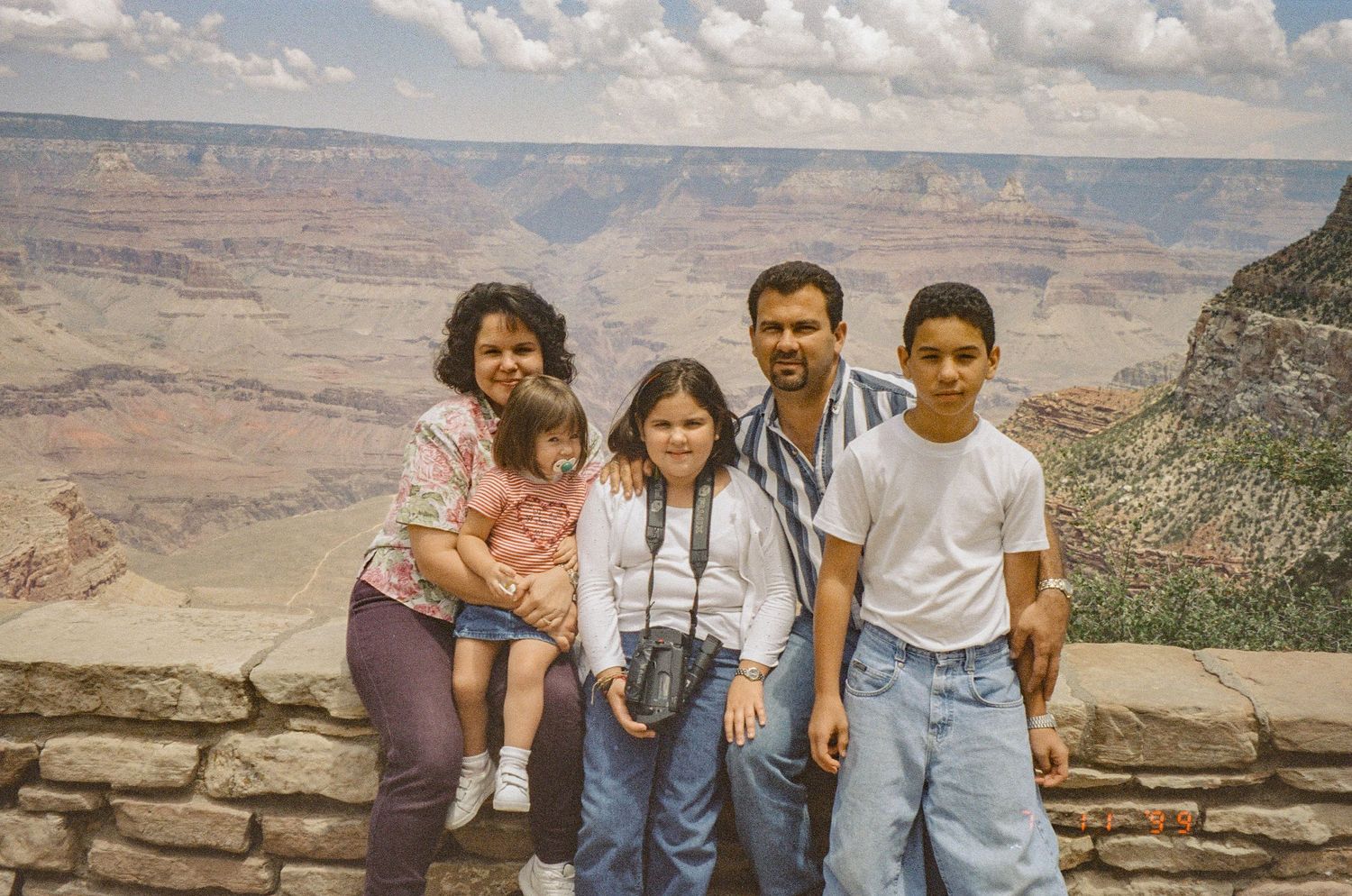 Scenic overlook at the Grand Canyon with stone wall and expansive canyon view.