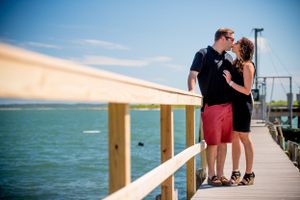 Casual summer boardwalk engagement session by the ocean at sunset.