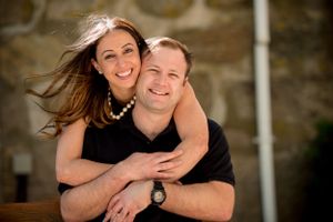 Sweet candid moments captured along wooden dock during casual photoshoot.