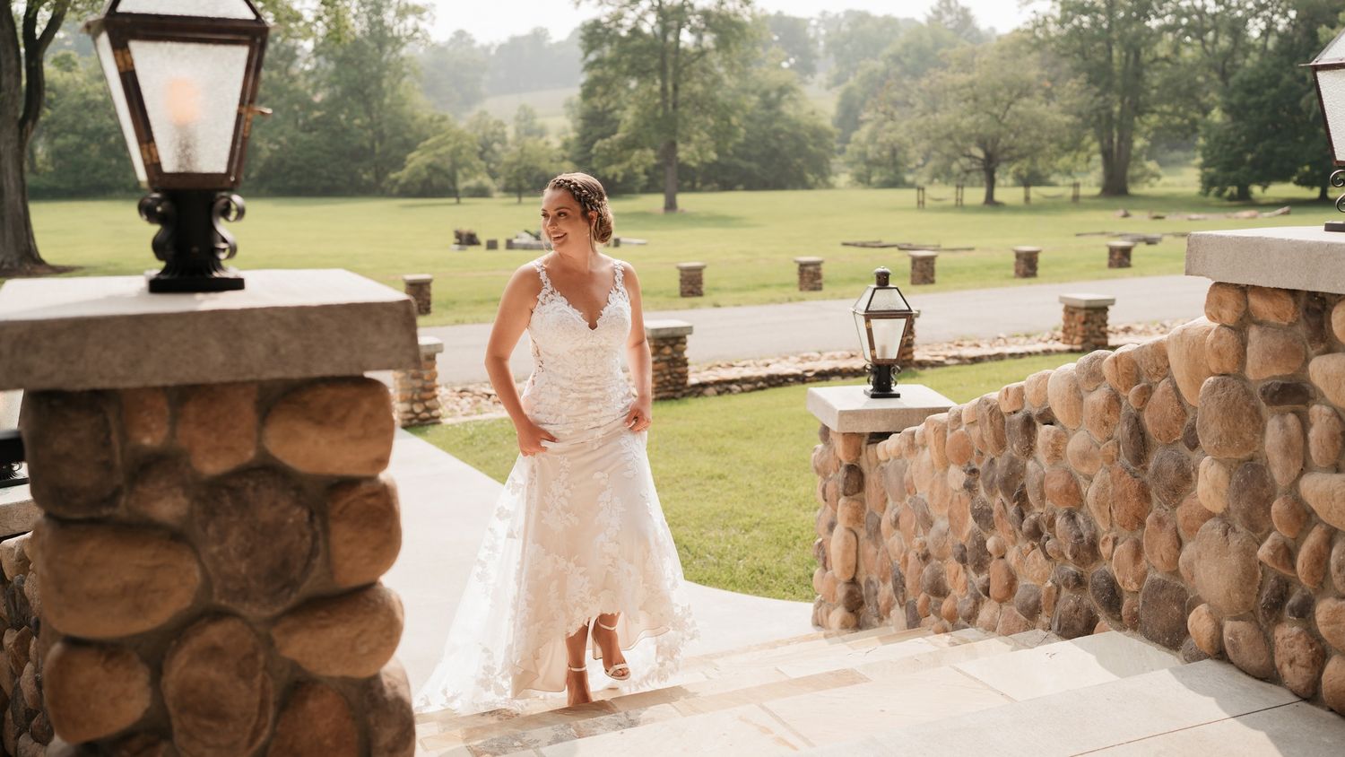 Stone pillared patio entrance to an elegant venue overlooking green landscape.