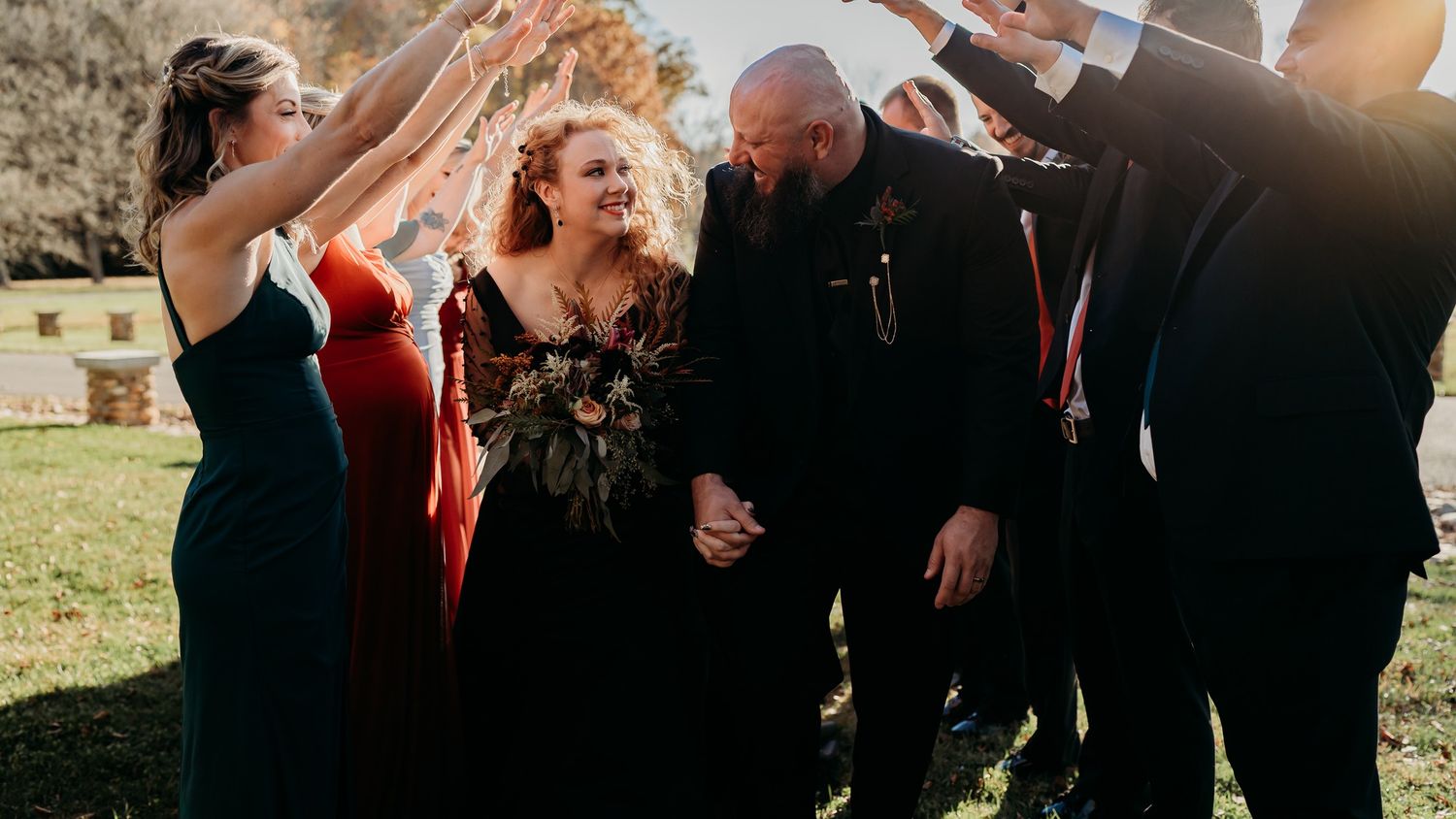 A joyful group celebrates together outdoors during a wedding celebration.