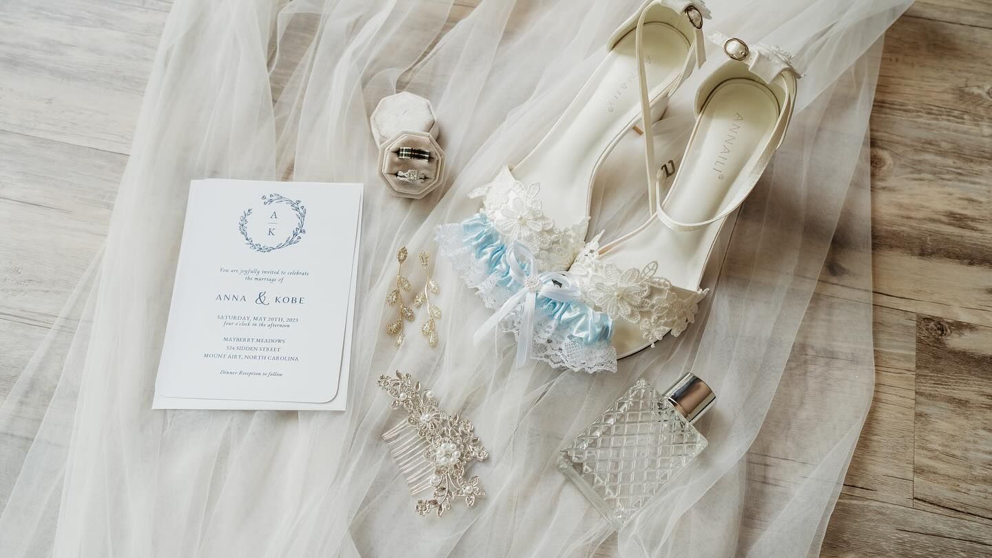 Wedding day flat lay with invitation, shoes, rings and something blue details.