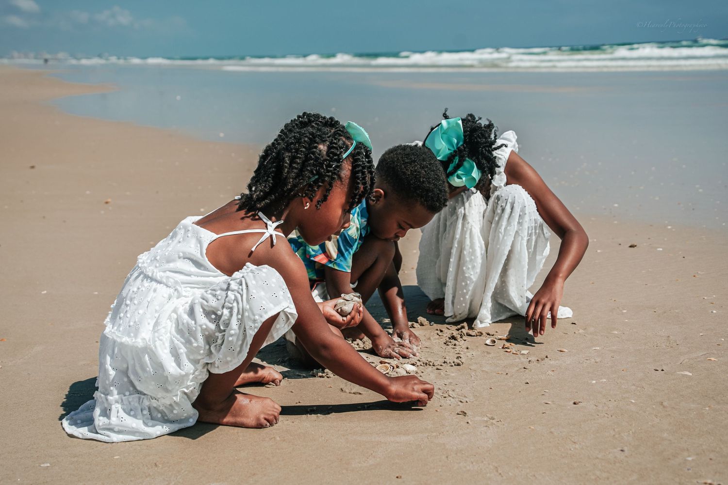Family members play in the sand during a casual beach photo session.