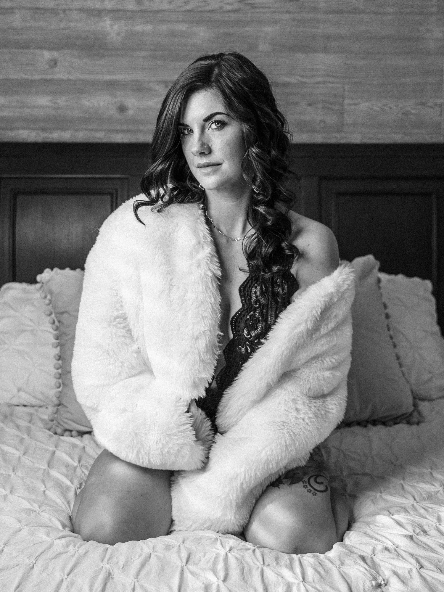 Boudoir portrait of a Knoxville woman sitting on a bed taken by East Tennessee boudoir photographer