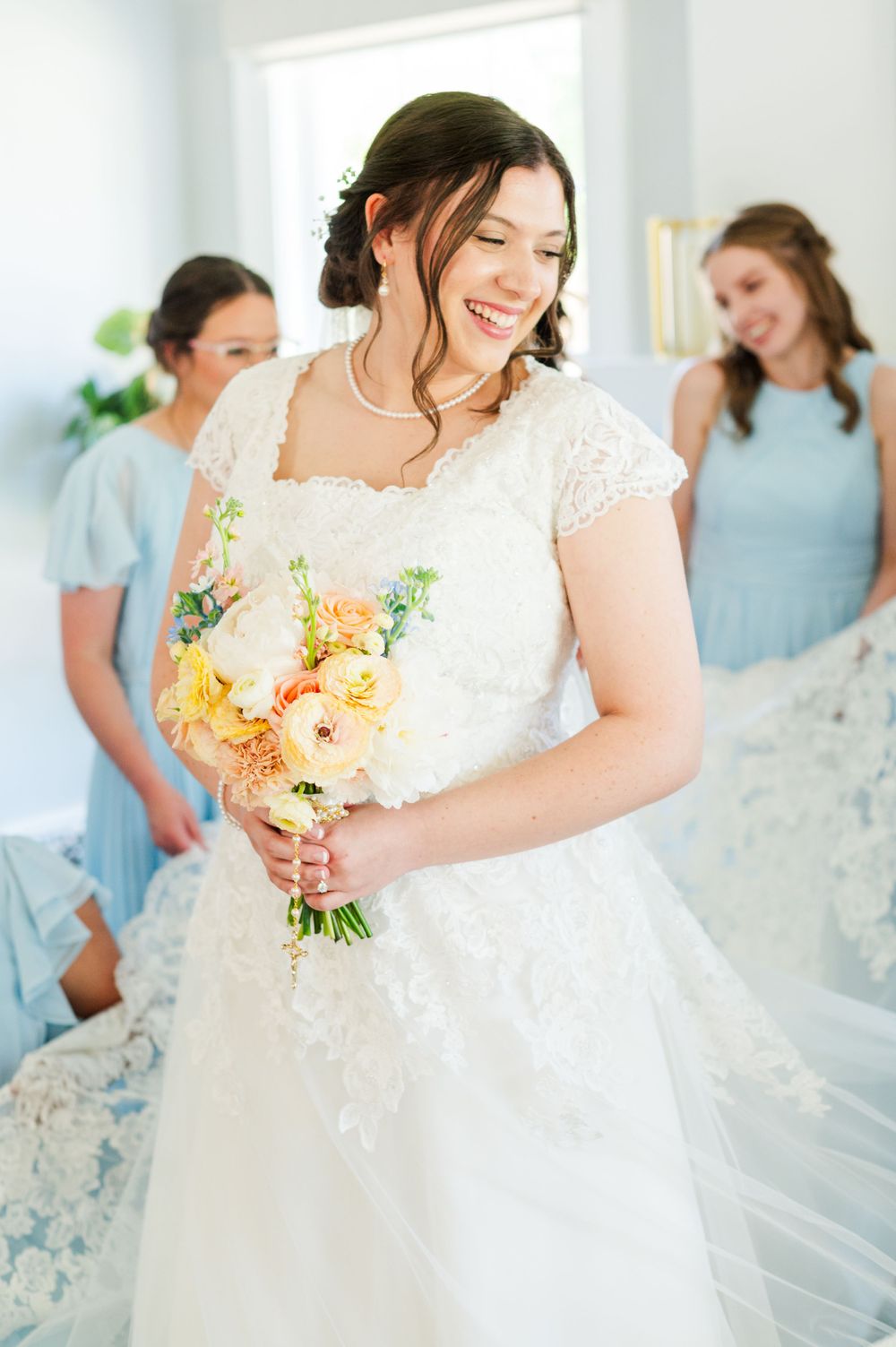 Bride laughs at her bridesmaids before her wedding at Parish of Christ the King in Tulsa, Oklahoma.
