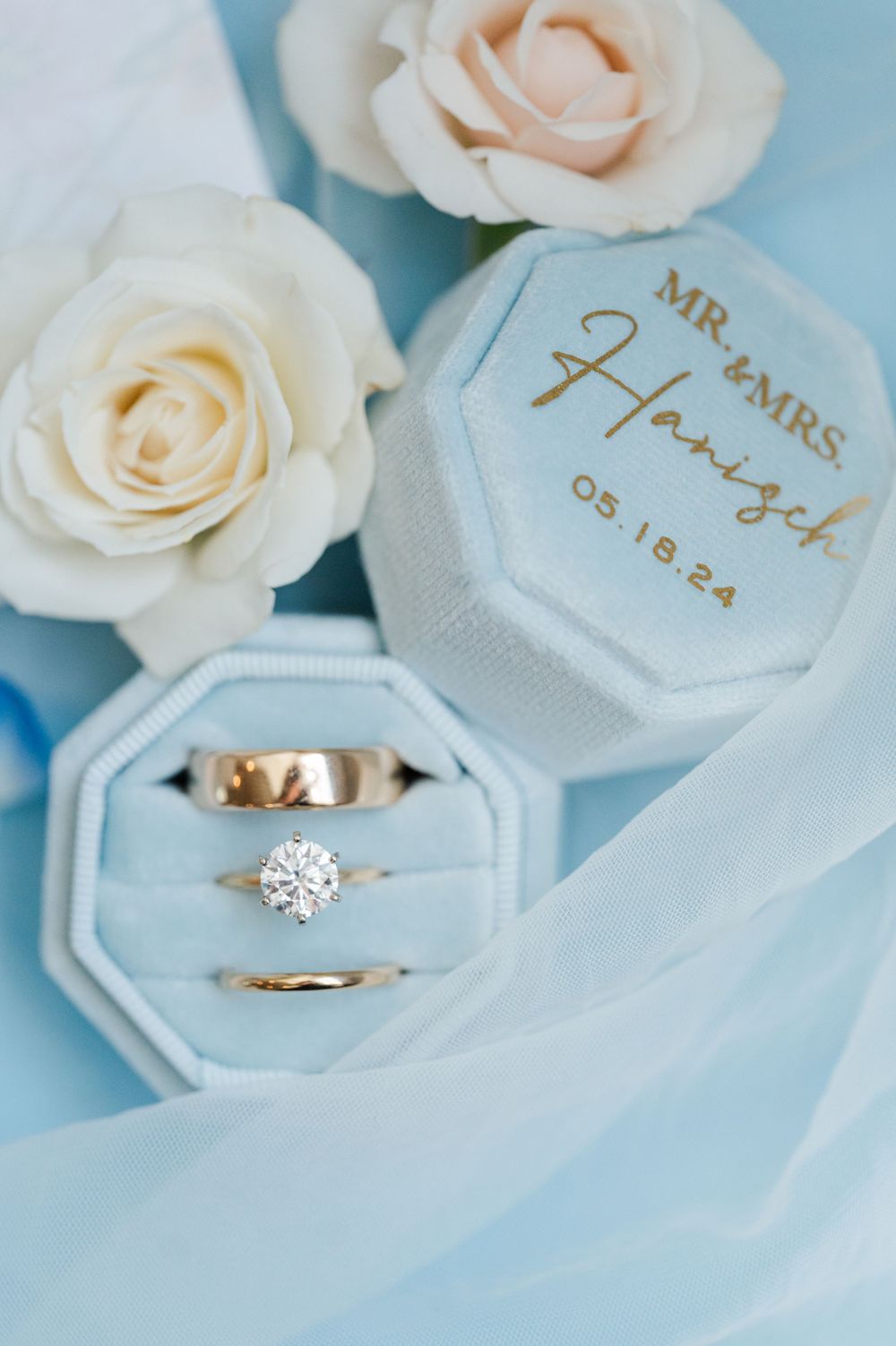 Wedding Jewelry and florals on a blue background for a Catholic, pastel summer wedding.