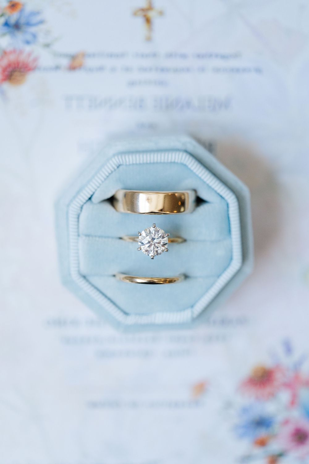 Wedding Jewelry and florals on a blue background for a Catholic, pastel summer wedding.