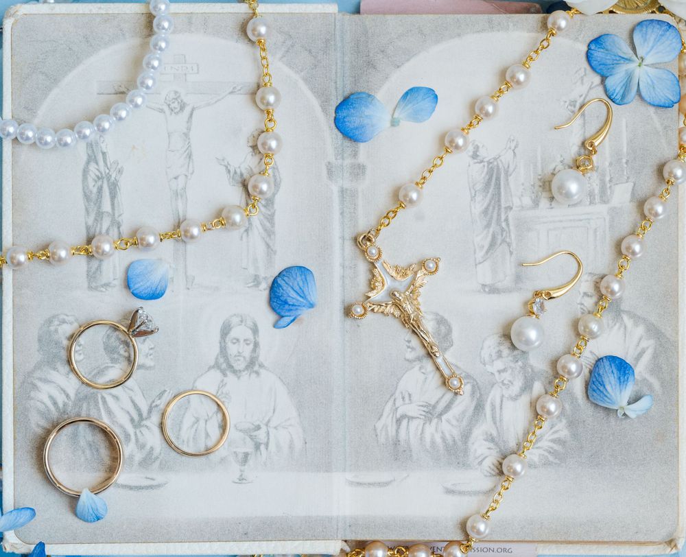Bridal jeweral and rosary sit on a Sunday Missal with Catholic imagery.