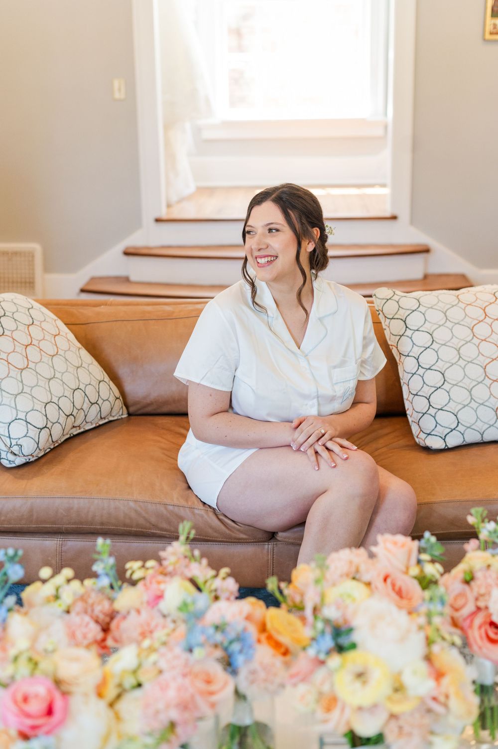 Bride excitedly looks out the window towards the church before her wedding at Parish of Christ the King in Tulsa, Oklahoma.
