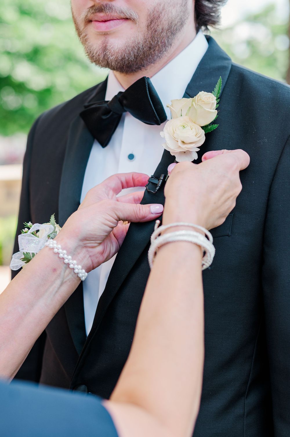 Mother of the Groom pins boutonniere on her son before his wedding at Parish of Christ the King in Tulsa, Oklahoma.