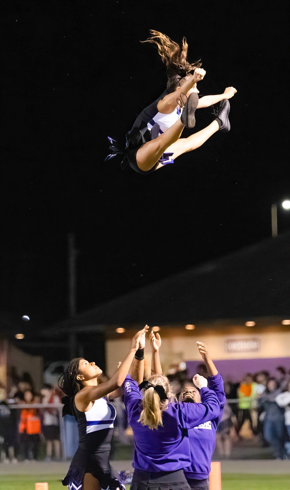 Dramatic nighttime cheerleading stunt shows performer being tossed high into the air.
cheer kanawha county riverside