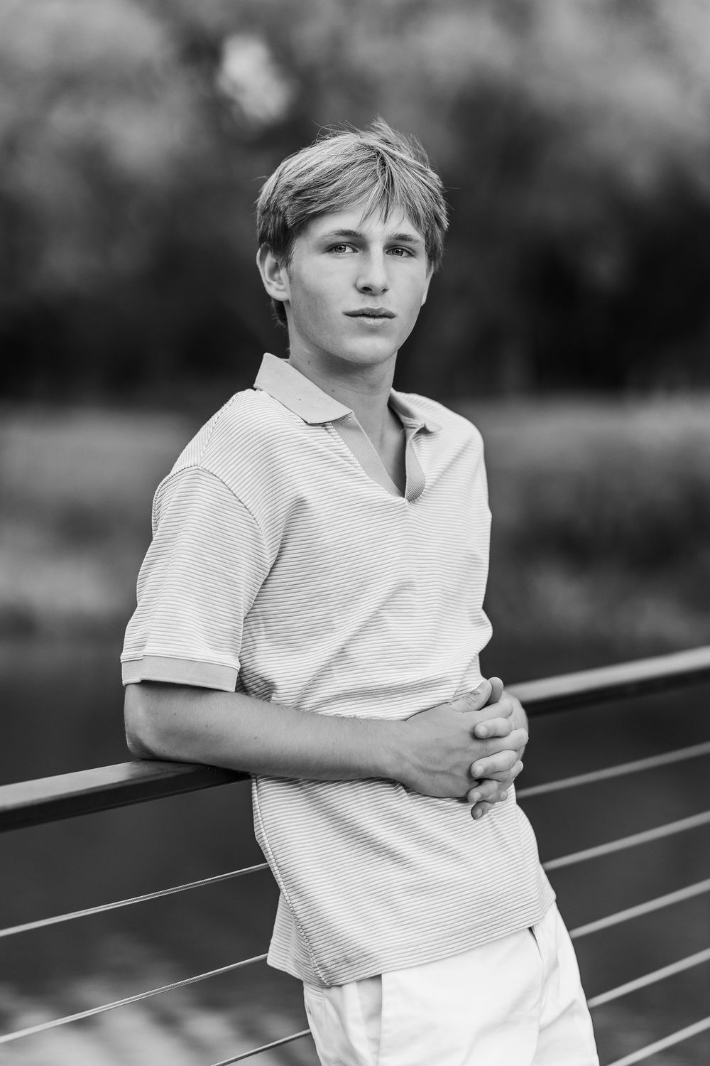 Black and white photo series of a young child in a white t-shirt leaning against outdoor metal railings.