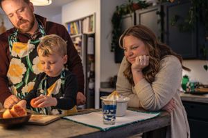Family cooking together in kitchen while sharing a relaxed moment.
