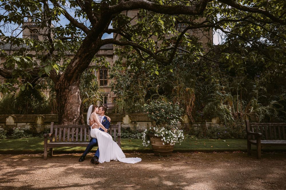 A romantic moment captured on a garden bench surrounded by historic stone architecture and greenery at Balliol College, Oxford