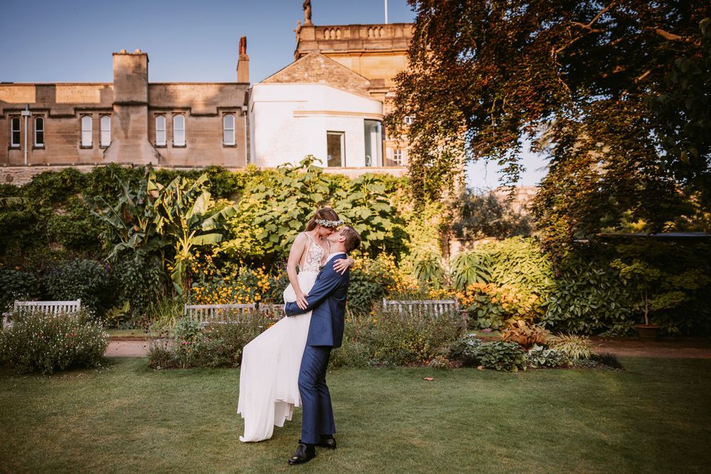 A celebratory moment in a garden with ivy-covered historic architecture during sunset at Balliol College, Oxford