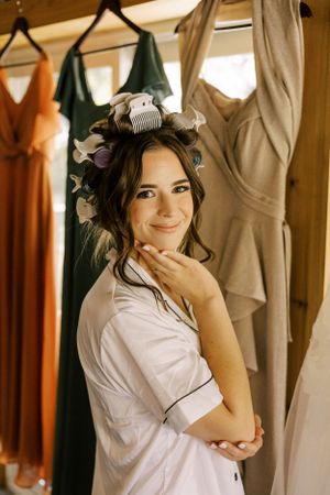 Getting ready scene with bridesmaid robes and dresses hanging in background.