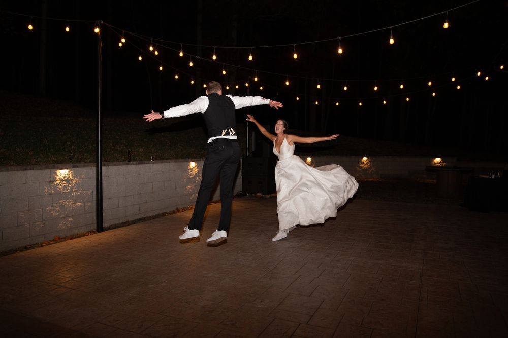 Wedding reception dance floor scene with string lights creating romantic ambiance overhead.