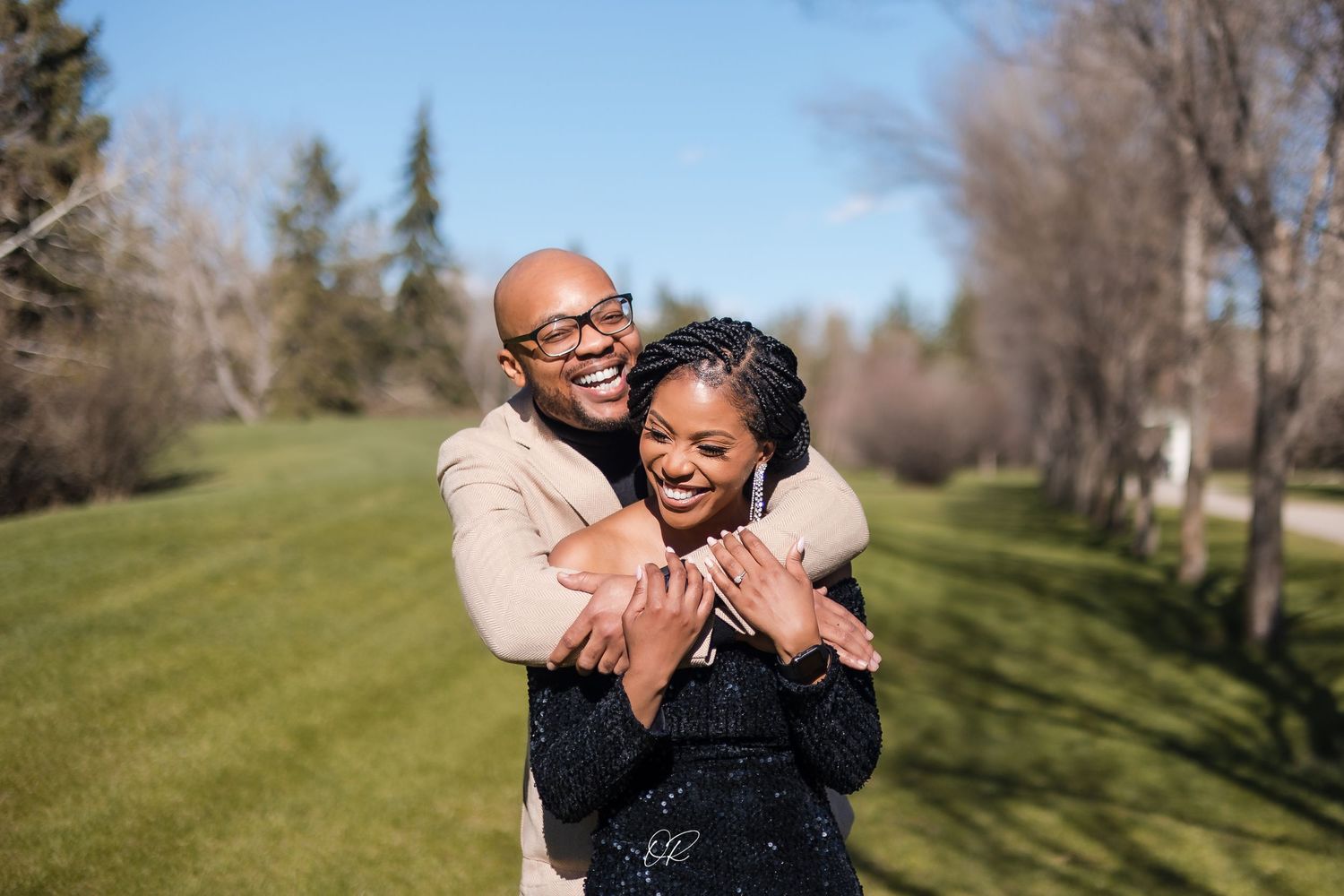 A couple embracing each other during their engagement shoot at a park in Calgary.