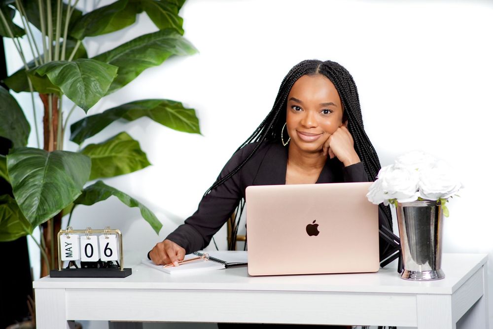 Bright home office setup with MacBook, desk calendar and tropical plant decor.