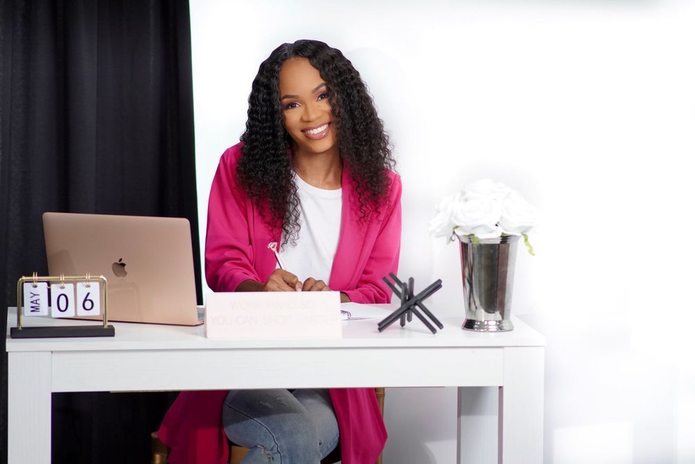 Vibrant pink blazer outfit in contemporary white home office setting.