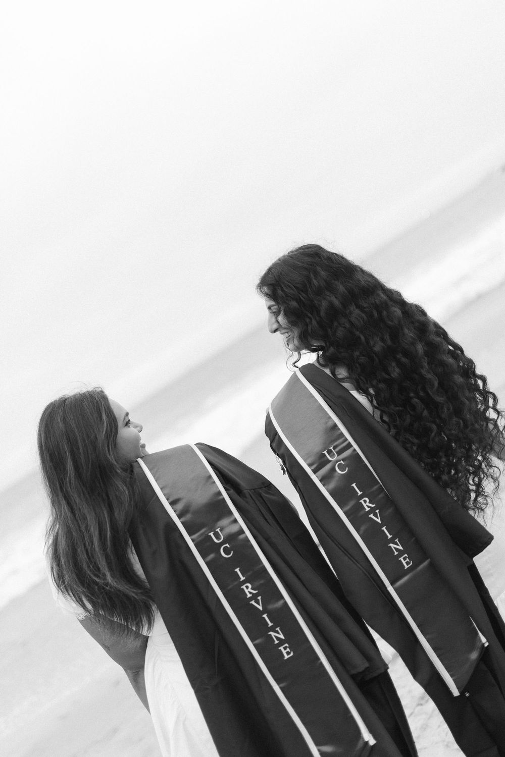 UC Irvine graduate duo celebrating graduation at Corona del Mar Beach