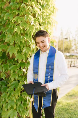 UCI male grad student celebrating with graduation photos, super easy to book
