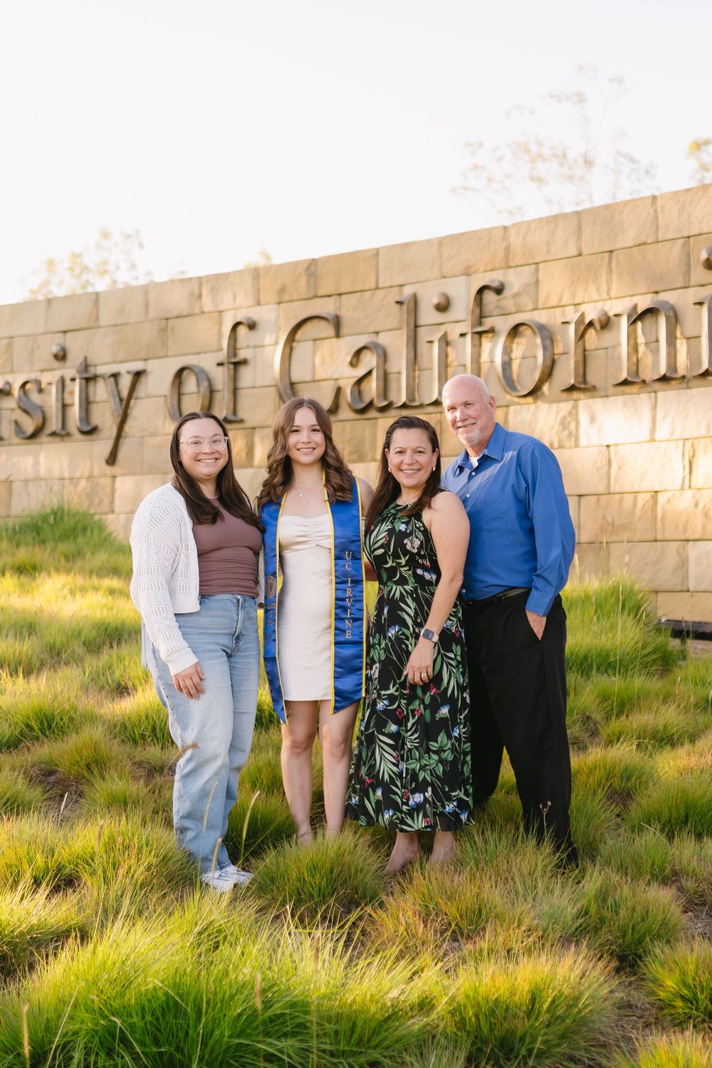 UCI graduate in cap and gown during family graduation photo session