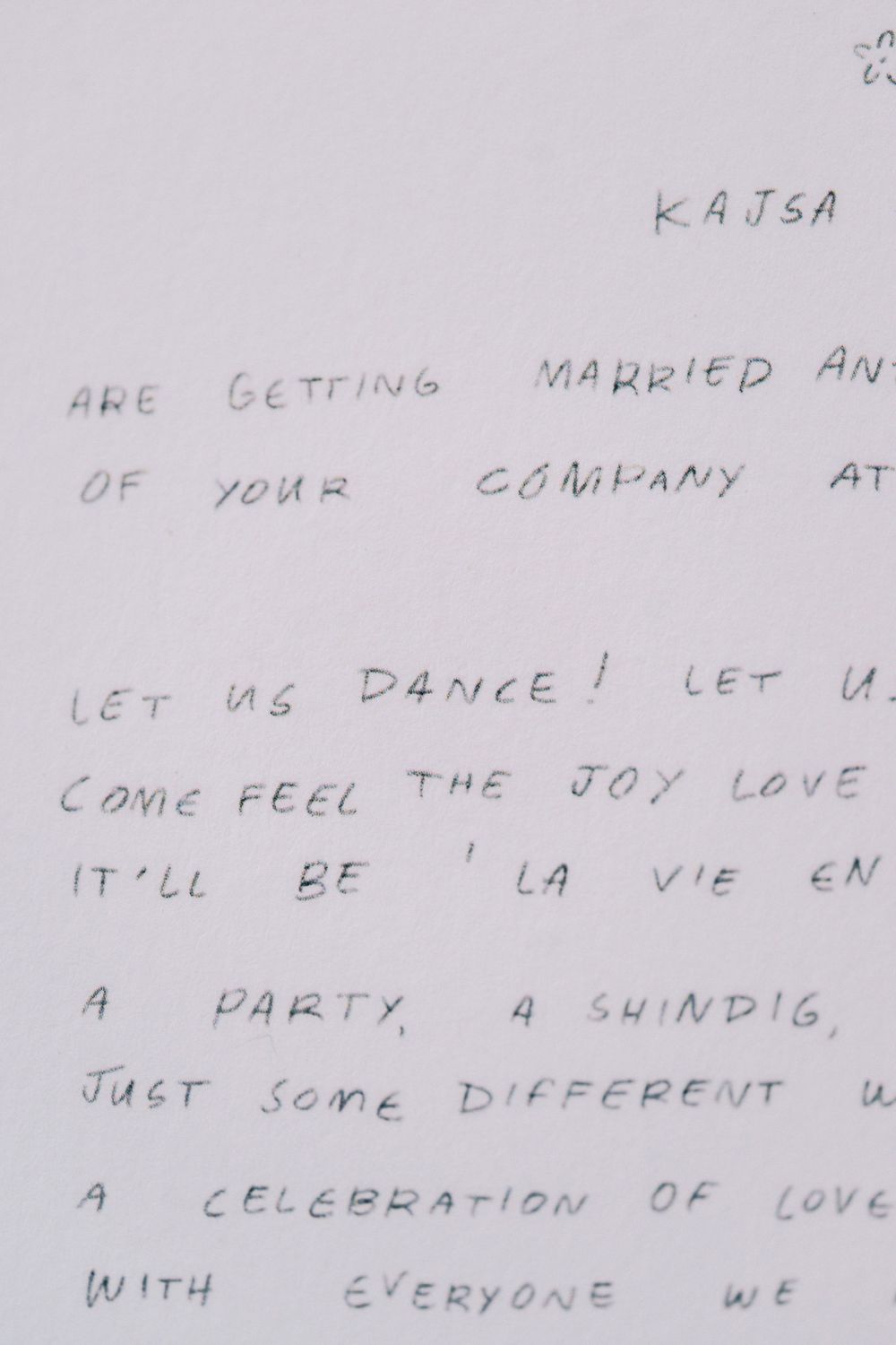 A handwritten wedding invitation note with text about dancing and celebration.