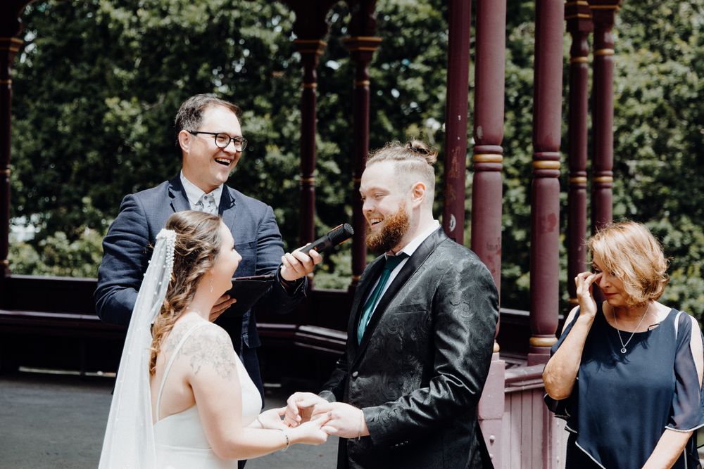 A couple exchanges vows during an outdoor wedding ceremony, captured by Apertured Media Auckland Wedding Photographer.