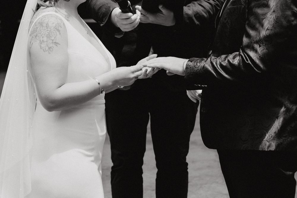 The bride and groom exchange rings, captured by Apertured Media Auckland Wedding Photographer.