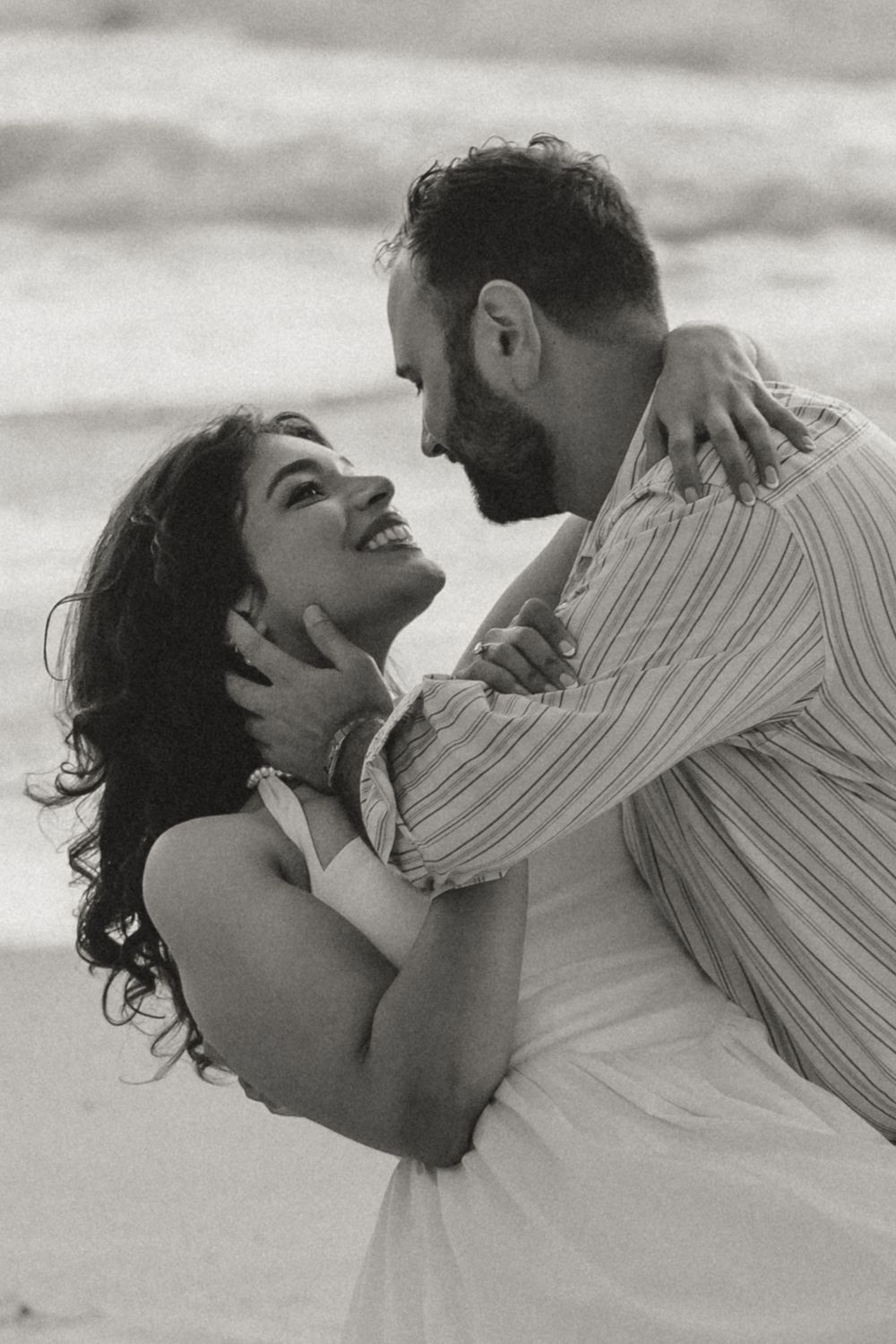 A romantic black and white photo sequence showing a couple embracing and kissing on the beach.