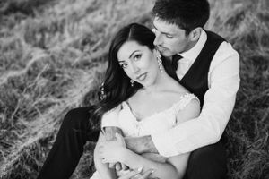 Intimate black and white portrait capturing tender moment between newlyweds in formal attire.