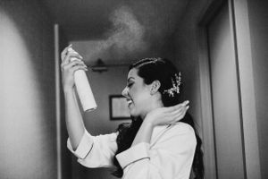 Black and white photo showing preparation with hairspray in getting ready room.