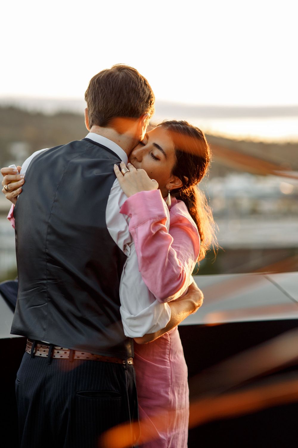 Intimate sunset moment shared between couple at outdoor wedding venue.