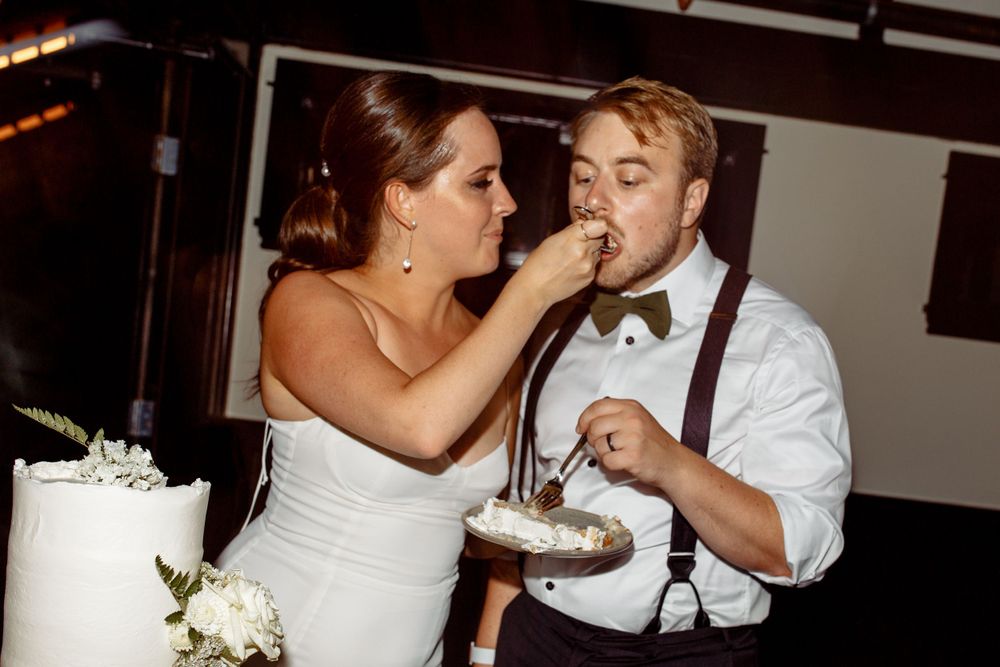 Wedding couple sharing cake during traditional cake cutting ceremony.