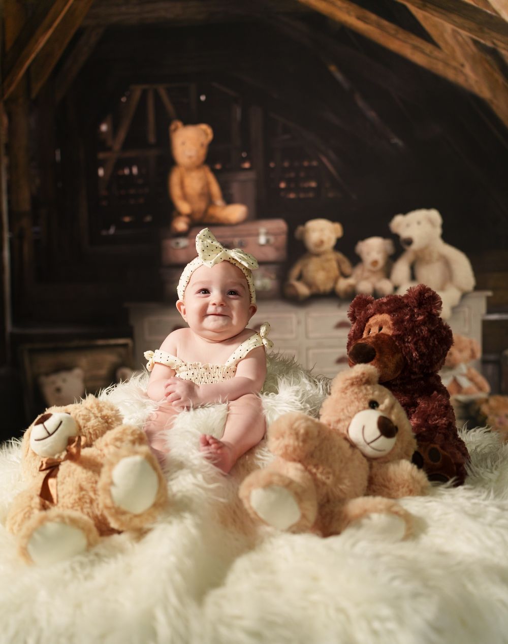 A fuzzy staged nursery scene featuring teddy bears on a white fluffy blanket with vintage decor in the background.