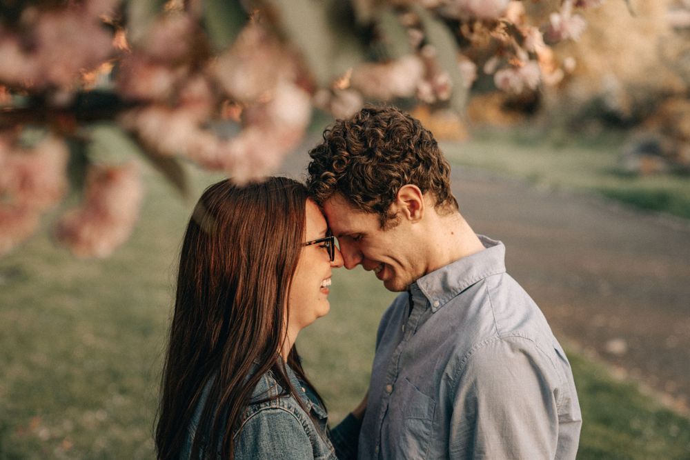 An intimate moment shared between a couple under spring blossoms.