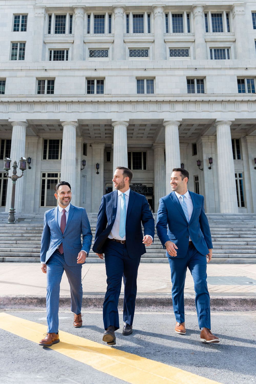 Three business professionals walking confidently in front of a historic building, showcasing leadership, teamwork, and corporate branding.