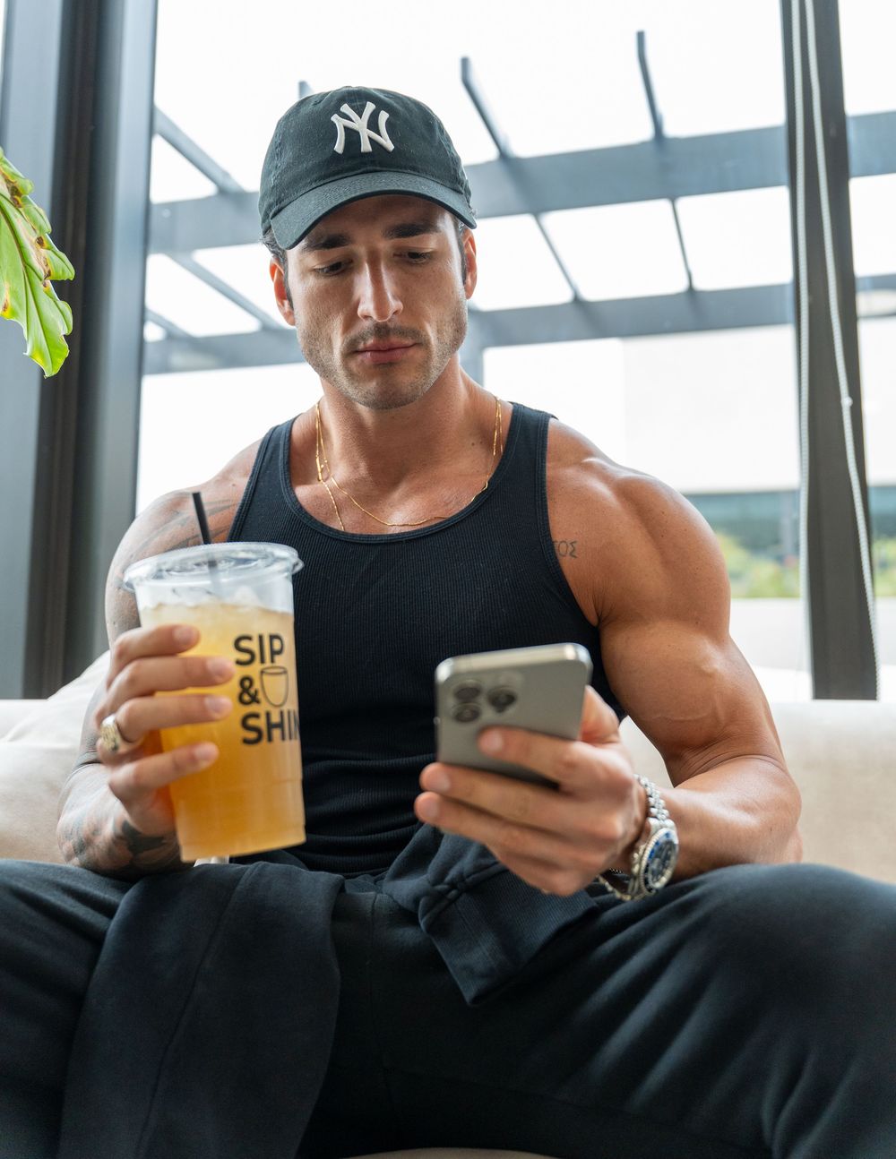 Fitness creator enjoying a Sip & Shine beverage while checking his phone, blending wellness, lifestyle, and brand content.