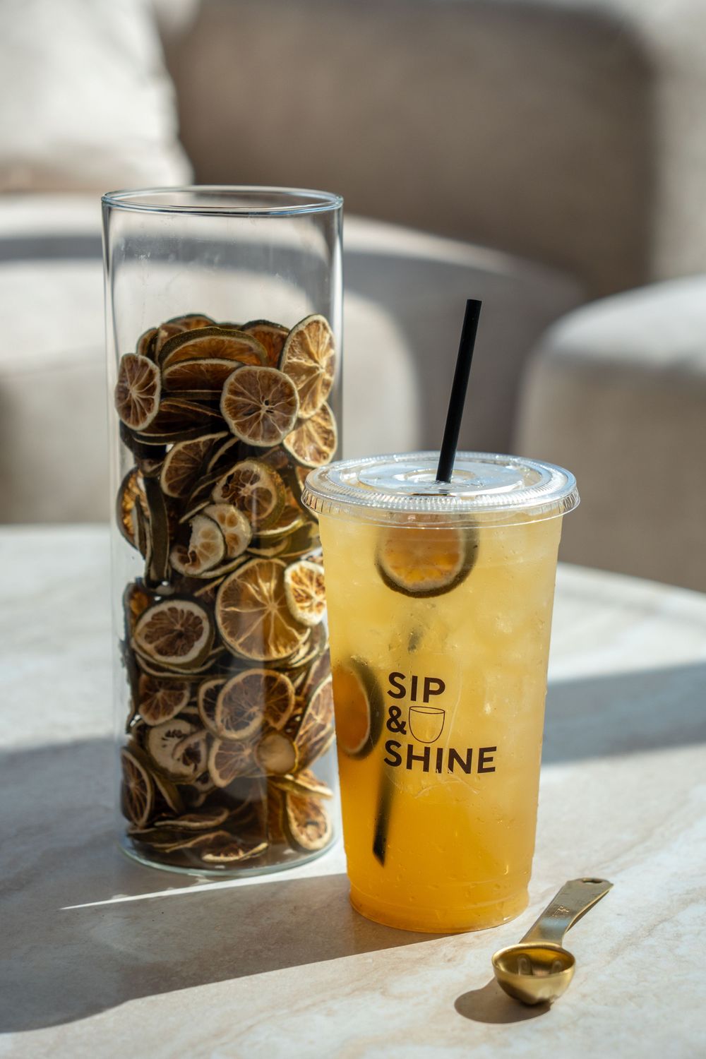 Lifestyle product photo featuring a branded citrus drink styled with dried citrus for a clean, premium café aesthetic.