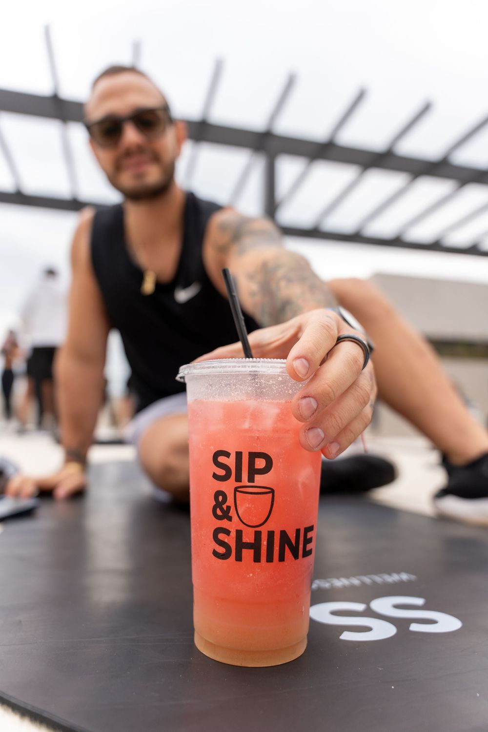 Fitness participant reaching for a Sip & Shine drink after a workout, highlighting refreshment and an active lifestyle.