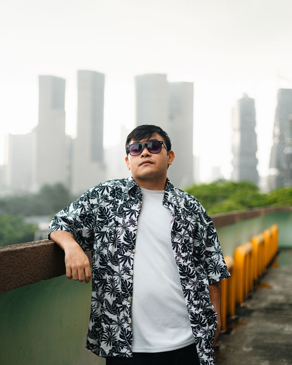Urban fashion photography featuring a black and white patterned shirt against city buildings.