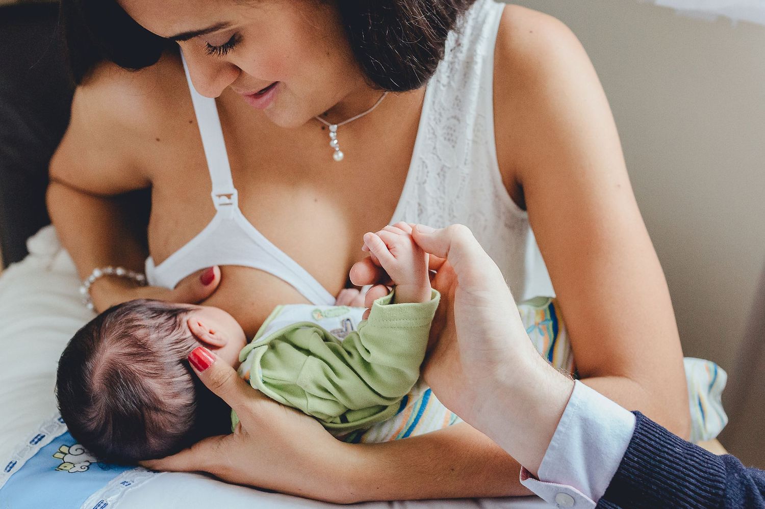 Eine Mutter hält ihr neugeborenes Baby liebevoll im Arm und stillt es, während sie sich ausruht.